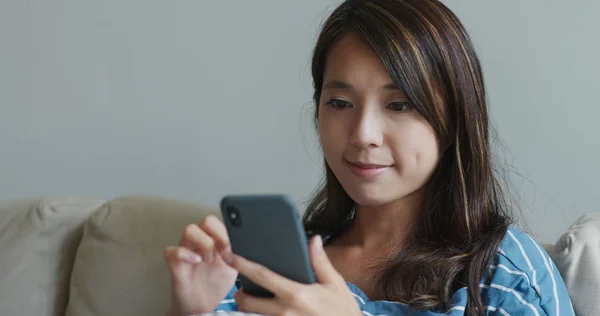 Kobieta patrzeć na telefon komórkowy w domu — Zdjęcie stockowe