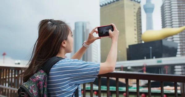 Женщина фотографирует город в Токио — стоковое фото