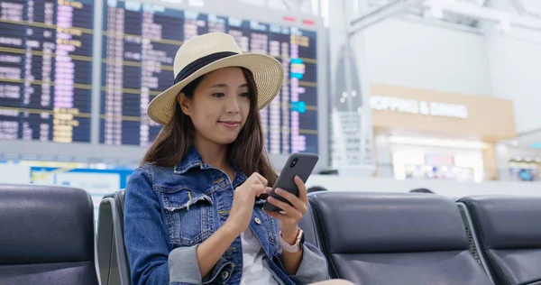 Woman use of cellphone to check the flight schedule at the airpo — Stock Photo, Image