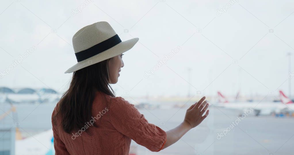 Woman look at the plane in the airport 