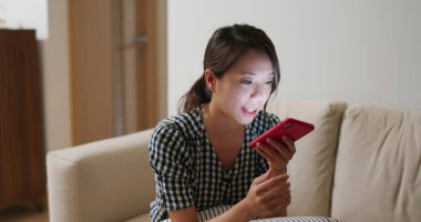 Kadın evdeki cep telefonundan sesli mesaj gönderiyor.