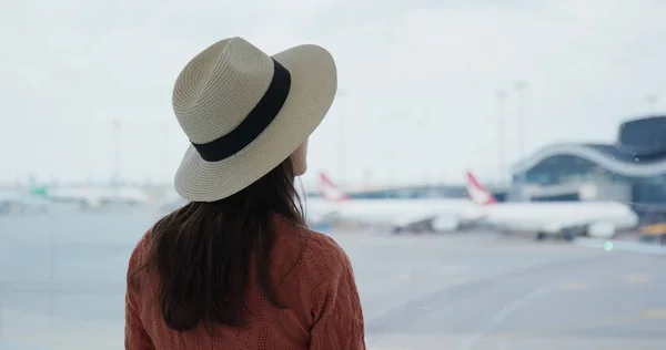 女は空港の外の窓を見て — ストック写真