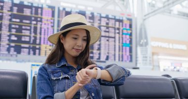 Havaalanında kadın akıllı saati kullanıyor.