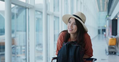 Mutlu kadın havaalanında uçağını bekliyor.