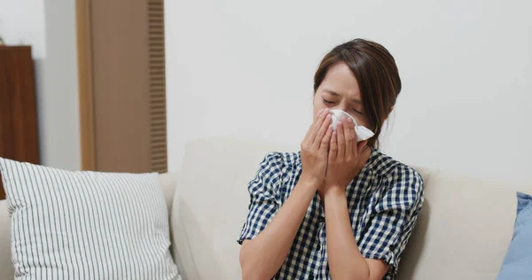 La mujer sufre de gripe, estornuda en casa — Foto de Stock