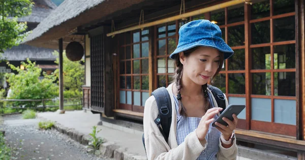 Mujer uso de teléfono móvil en la vieja casa japonesa — Foto de Stock