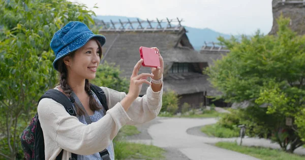 Frau fotografiert mit Handy in japanischem Holzhaus — Stockfoto