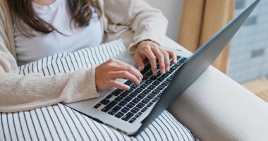 Kadın evde bilgisayar üzerinde çalışıyor