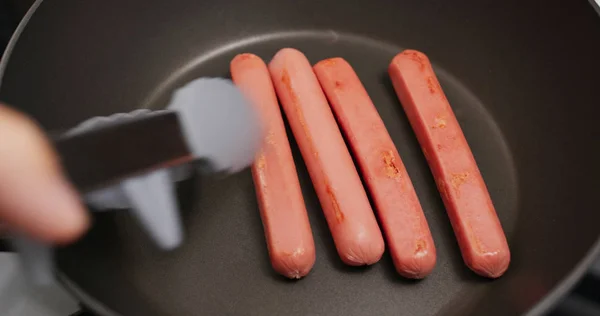 Cuisson des saucisses sur la casserole dans la cuisine — Photo