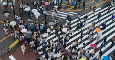 Tokyo, Japonya - 30 Haziran 2019: Geceleyin Ikebukuro ilçesinde insanlar karşıdan karşıya geçiyor