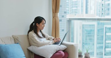 Kadın evde dizüstü bilgisayarda çalışıyor.