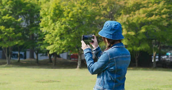 Woman use of mobile phone to take photo in countryside — Stock Photo, Image