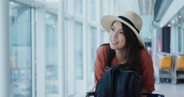 Happy woman waiting for her flight in the airport — Stock Photo, Image