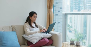 Kadın evde dizüstü bilgisayarda çalışıyor.
