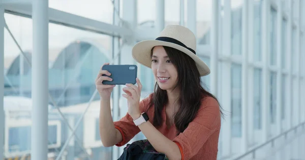 Vrouw nemen foto 's op mobiele telefoon in de luchthaven — Stockfoto