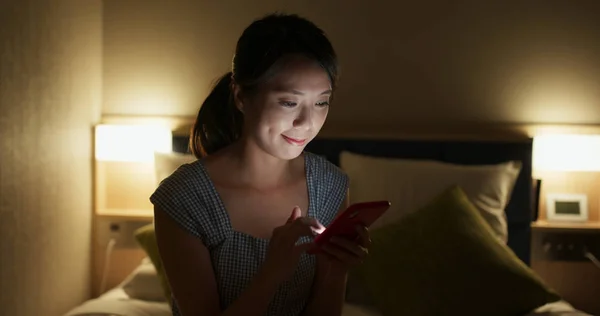 Korzystanie przez kobietę ze smartfona w nocy w łóżku — Zdjęcie stockowe