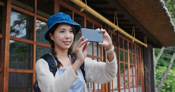 Женщина сфотографироваться с сотовым телефоном в японской старой деревне деревянные ч — стоковое фото