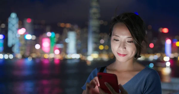 Mulher uso de telefone celular na cidade de Hong Kong à noite — Fotografia de Stock