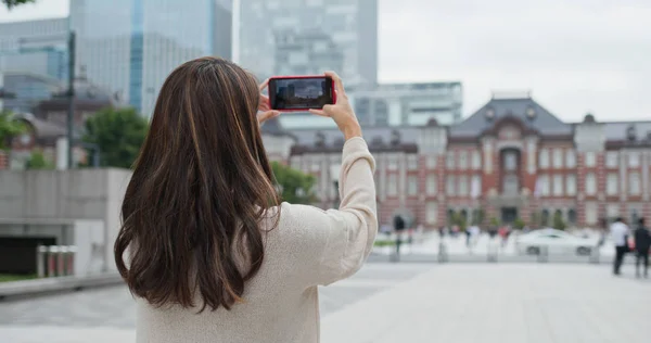 Woman take photo on cellphone in Tokyo station — Stockfoto