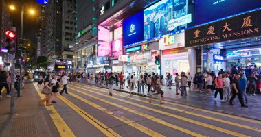 Tsim Sha Tsui, Hong Kong - 06 Temmuz 2019: İnsanlar geceleri caddeden karşıya geçiyor
