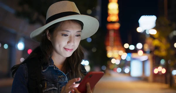 Woman use of mobile phone in Tokyo city at night