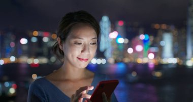 Geceleri kadın akıllı telefon kullanıyor.