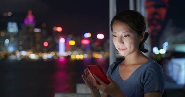 Geceleri kadın cep telefonu kullanıyor.