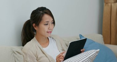 Kadın evde dijital tablet bilgisayardan izliyor