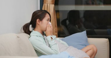 Hasta kadın hapşır ve evdeki kanepeye otur.