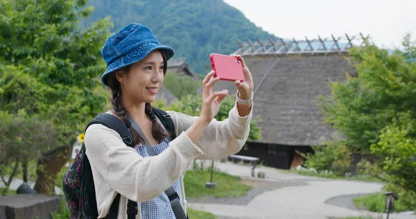 Frau fotografiert mit Handy in japanischem Holzhaus — Stockfoto