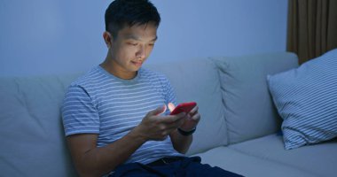 Geceleri cep telefonu kullanan bir adam