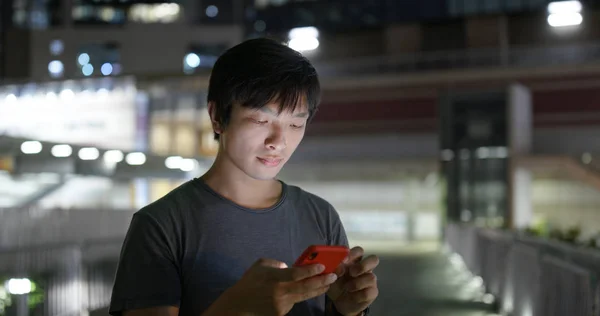 Asiatisk man användning av mobiltelefon i City på natten — Stockfoto