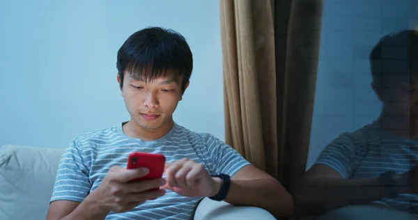 Homem uso de telefone celular on-line à noite — Fotografia de Stock