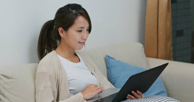 Kadın evde dizüstü bilgisayarda çalışıyor.