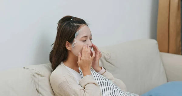 La mujer aplica mascarilla facial en la cara en el hogar —  Fotos de Stock