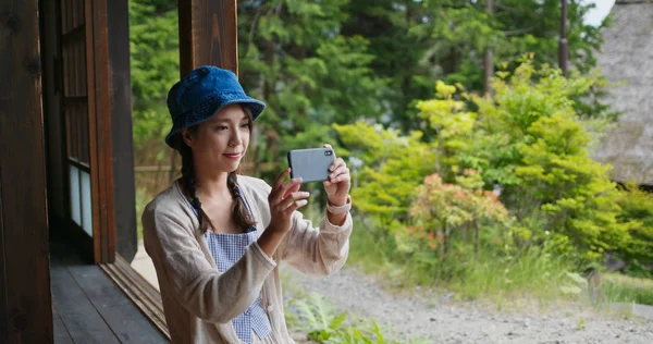 Mujer visita japonesa antigua casa de pueblo y el uso de teléfono móvil t — Foto de Stock