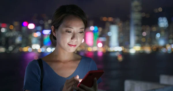 Nő használata okos telefon a városban éjszaka — Stock Fotó