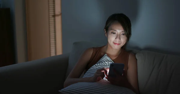 Mujer uso del teléfono móvil en casa por la noche — Foto de Stock