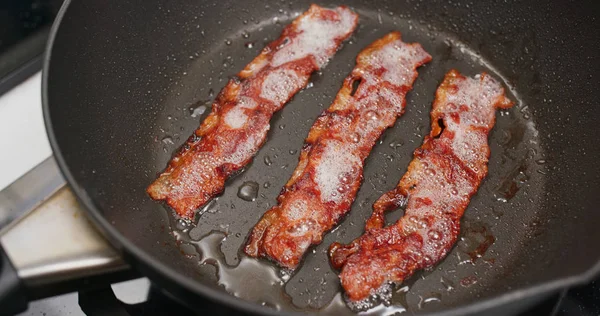 Cottura pancetta sulla padella in cucina per la colazione — Foto Stock