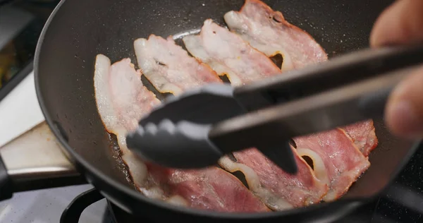 Cottura pancetta sulla padella in cucina per la colazione — Foto Stock