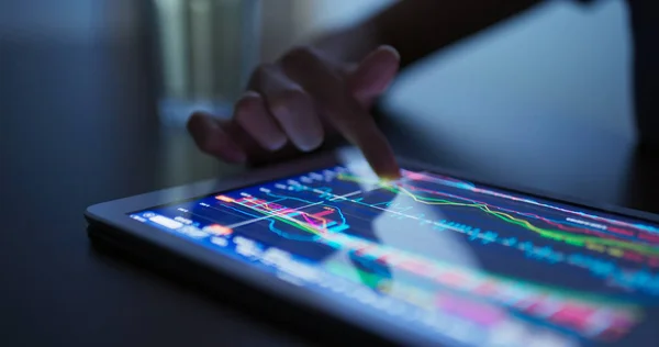 Finger touch on tablet computer with stock market data — Stock Photo, Image