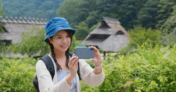 Жінка подорожує по сільській місцевості в Японії і користується мобільним телефоном до та — стокове фото