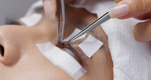 Esthéticienne et jeune femme dans un salon de beauté avec cils exten — Photo