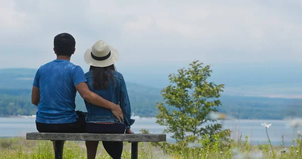 Un couple s'assoit ensemble dans le parc et regarde le paysage — Photo