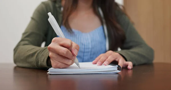 Mulher escreve no caderno em casa — Fotografia de Stock