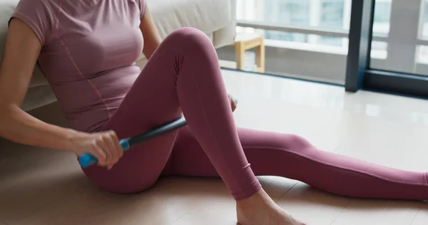 Vrouw gebruik van roller stick op de dij om pijn thuis los te laten — Stockfoto