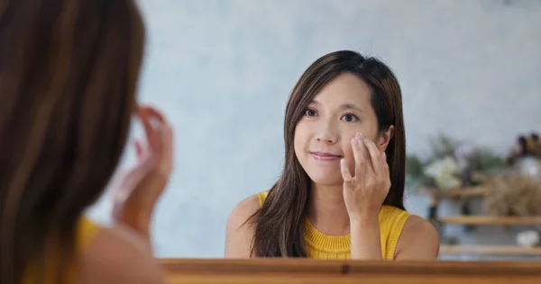 Женщина использовать прикосновение пальца на лице в красоте составляют студии — стоковое фото