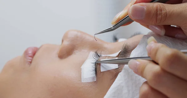 Beauty professional procedures eyelash extension on woman eyes — Stock Photo, Image