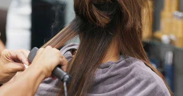 Donna che ha un trattamento di stiratura dei capelli nel salone di parrucchiere — Foto Stock