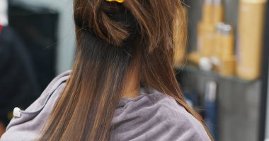 Woman having hair straightening treatment in hair salon